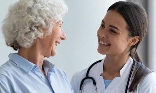 Primary Care Nurse Practitioner Smiling with Adult Female Patient 